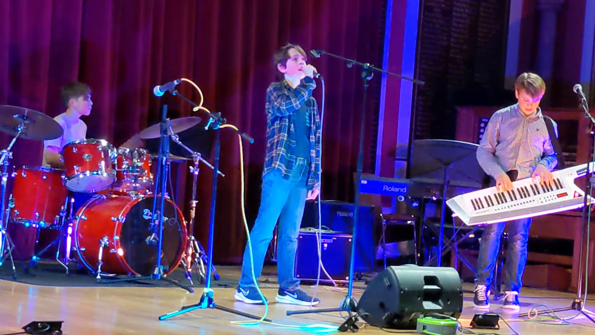 Tom playing drums while his school band performs