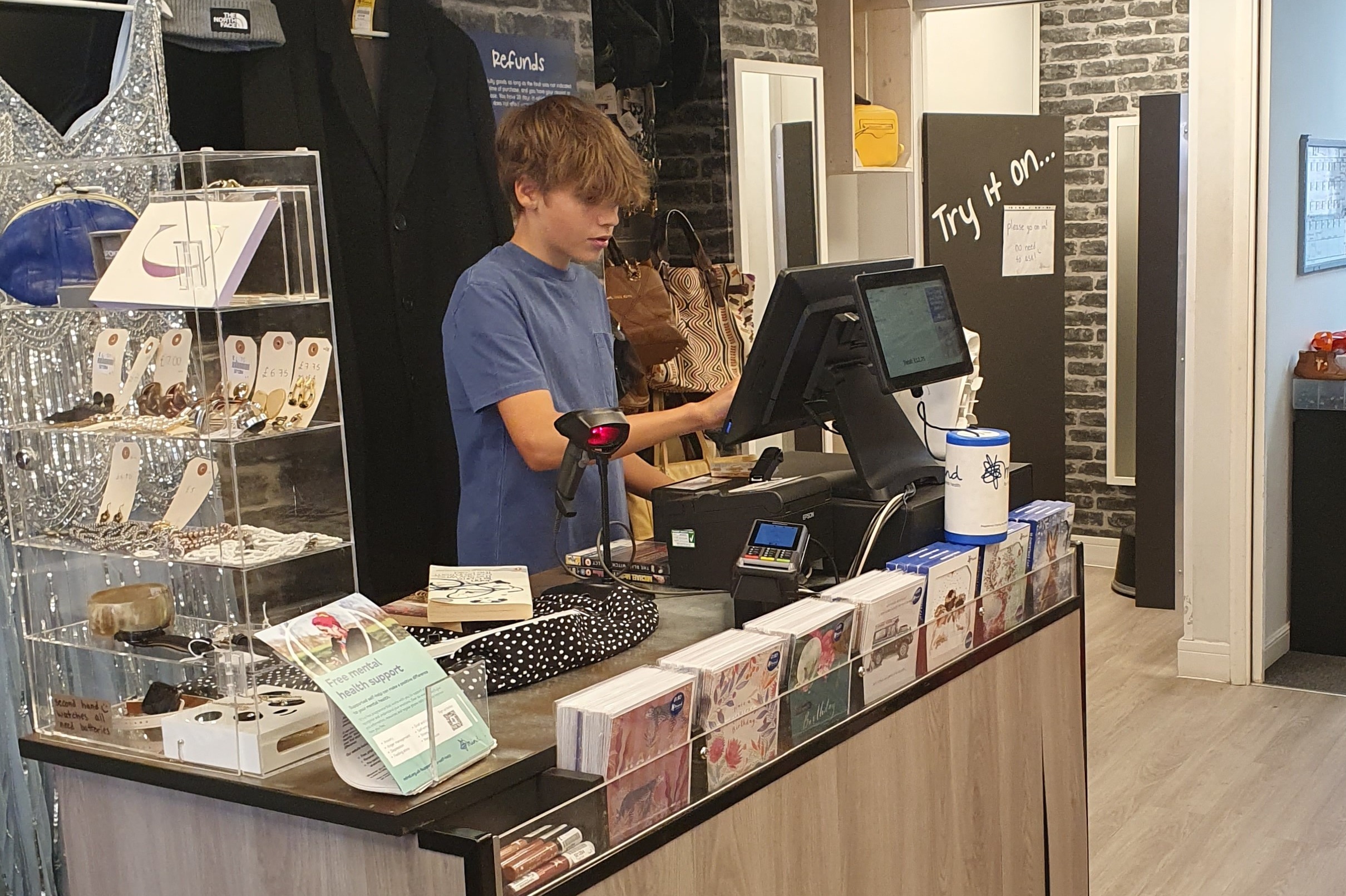 Tom working at the till in a Mind charity shop