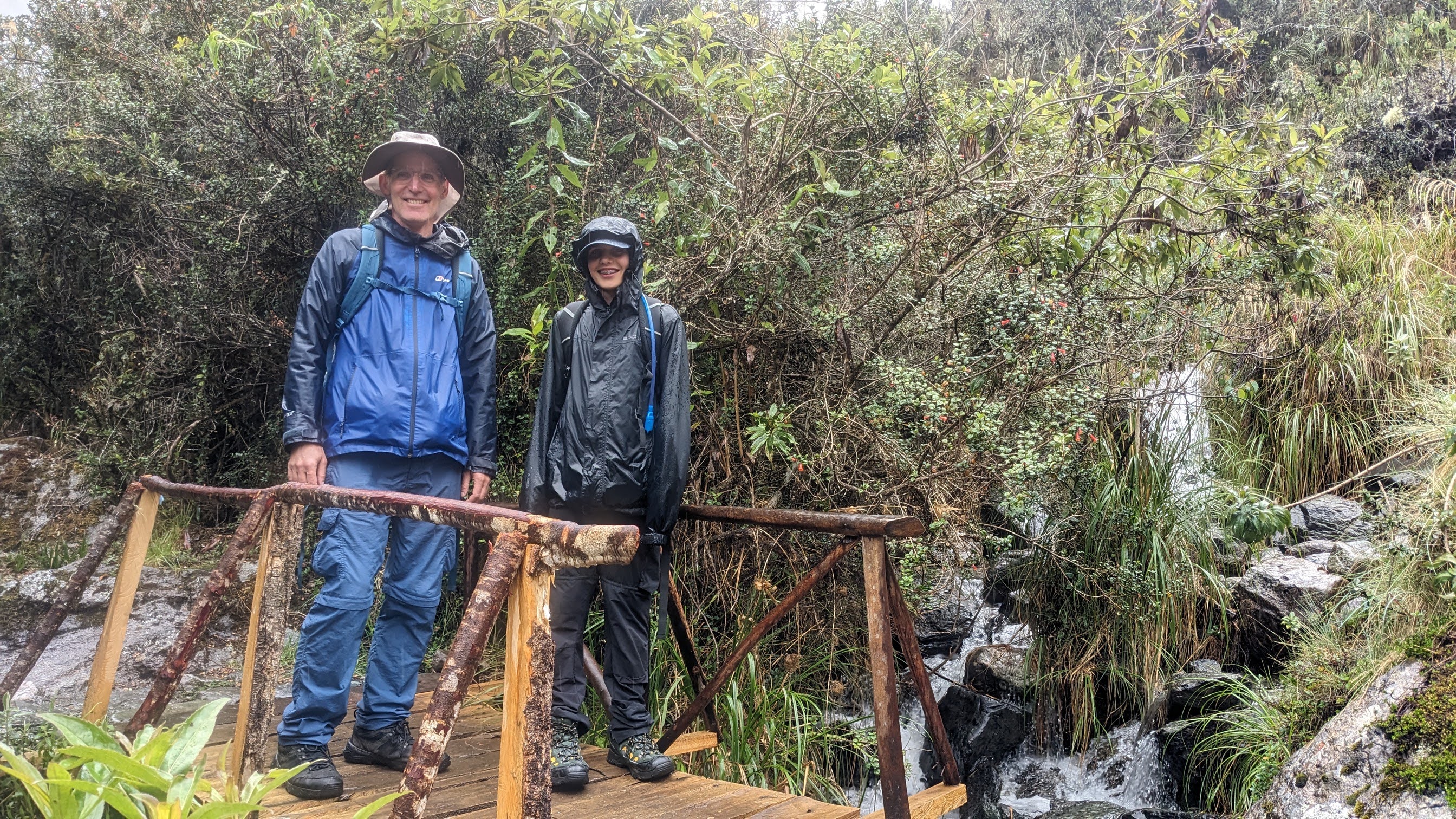 Tom and his dad hiking in rain on the Machu Picchu trail